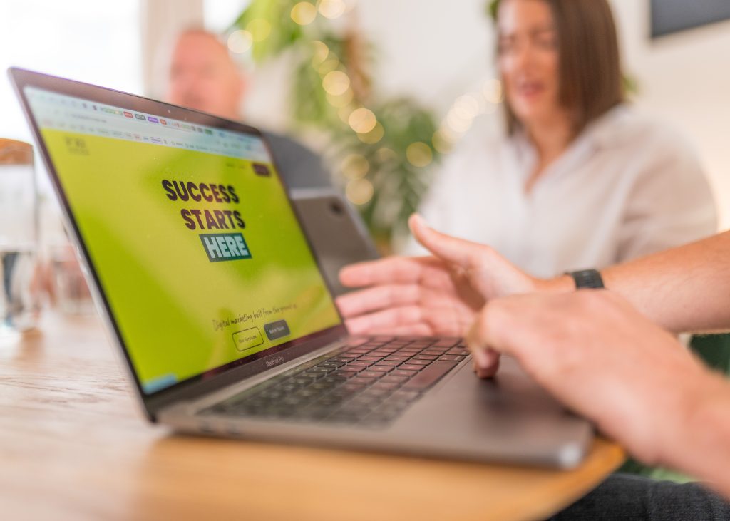 Open laptop with FORJ Digital website.